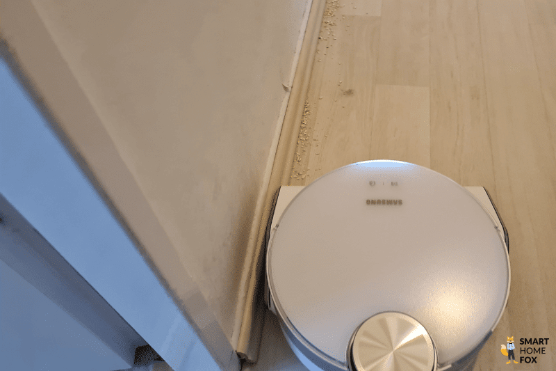 Der Samsung Jet Bot AI+ reinigt Schmutz entlang einer Leiste.